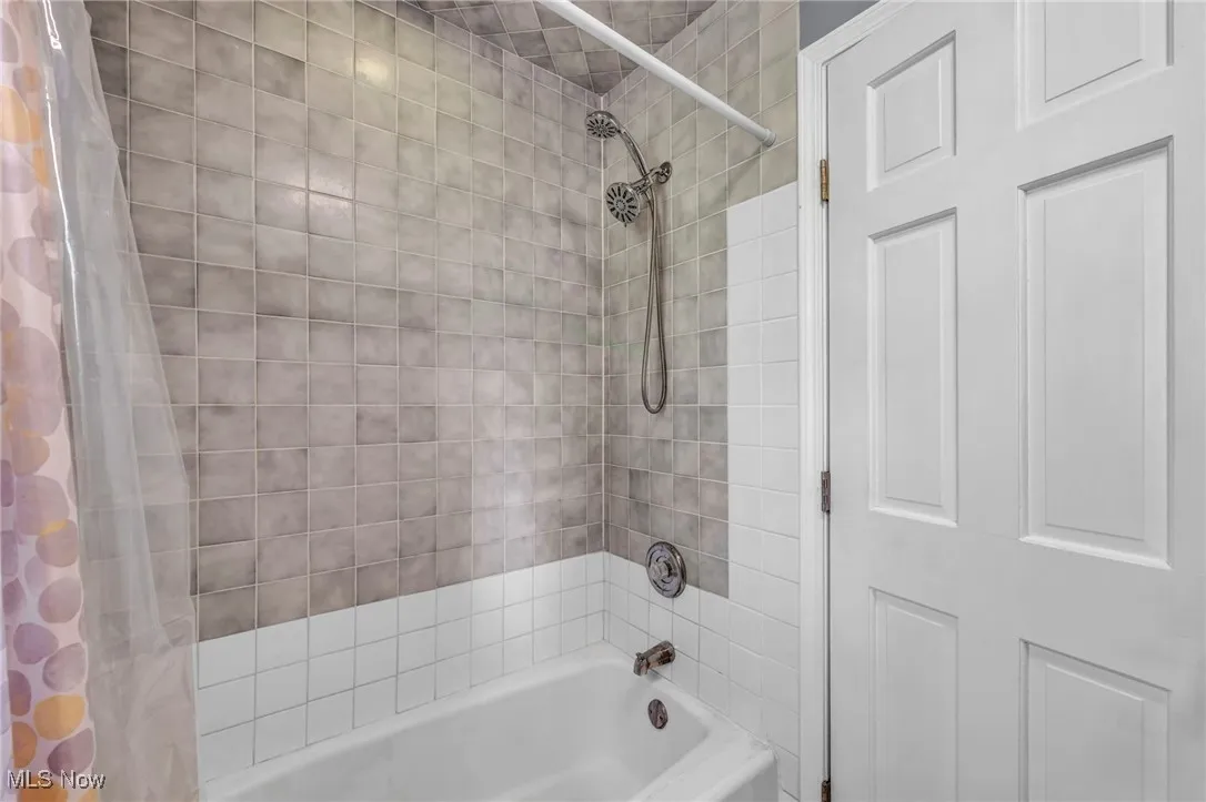 Bathroom with shower / bath combination with curtain