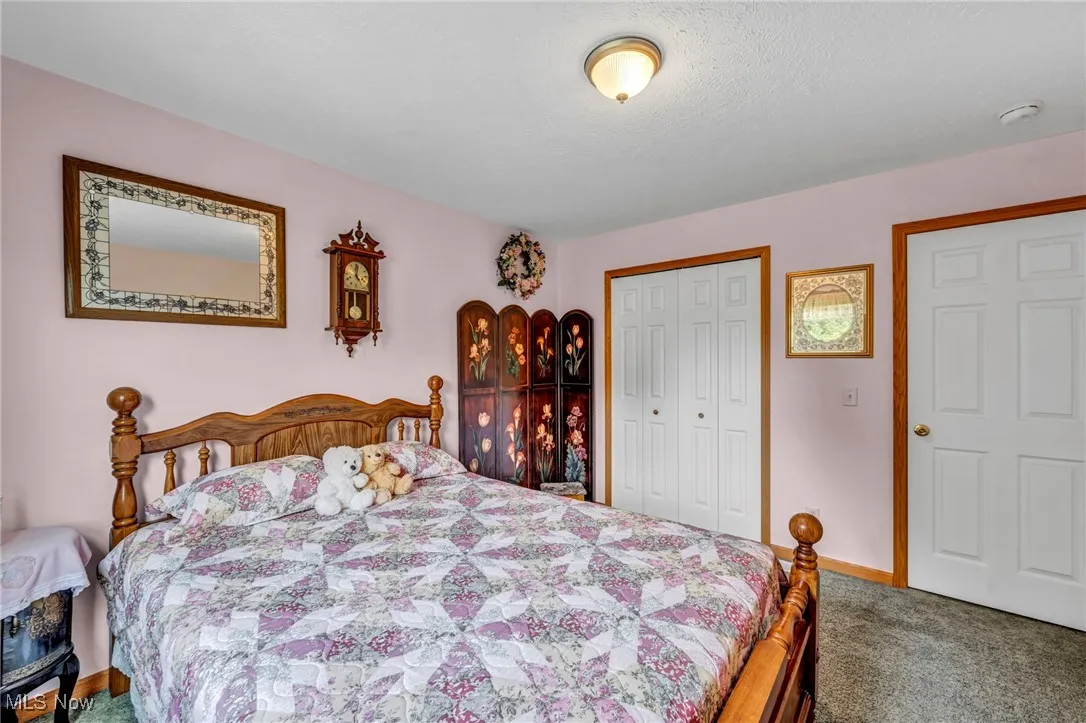 Carpeted bedroom featuring a closet and a textured ceiling