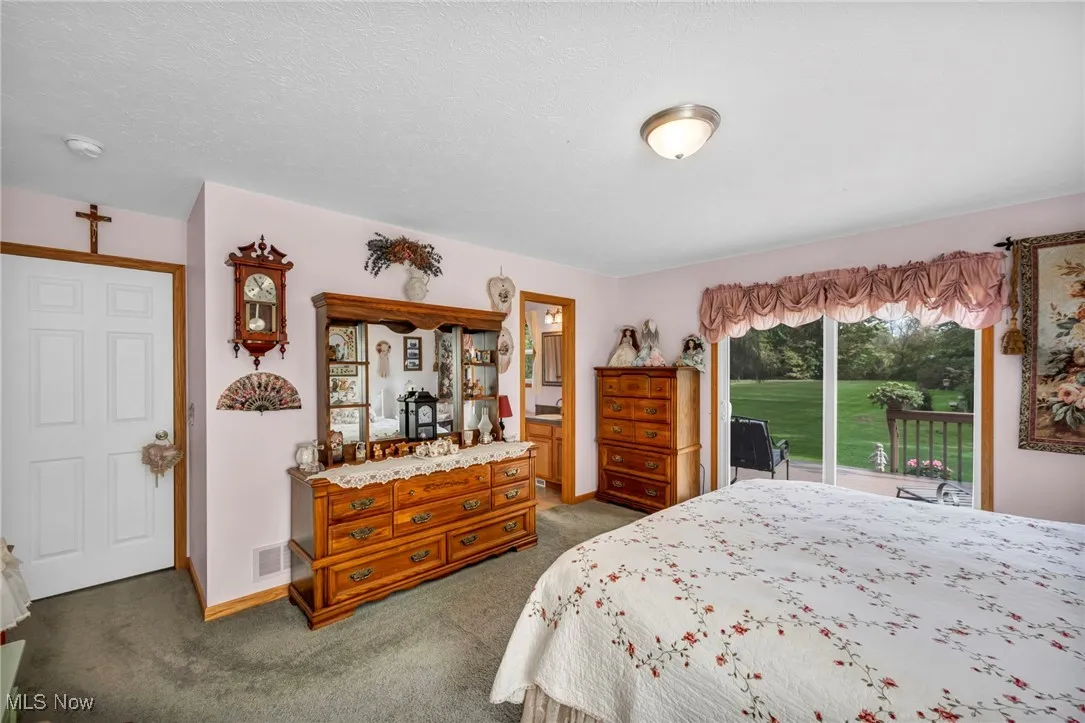 Carpeted bedroom featuring access to exterior, connected bathroom, and a textured ceiling