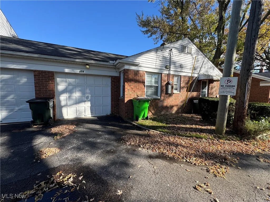 View of front of property with brick siding, asphalt driveway, and a garage