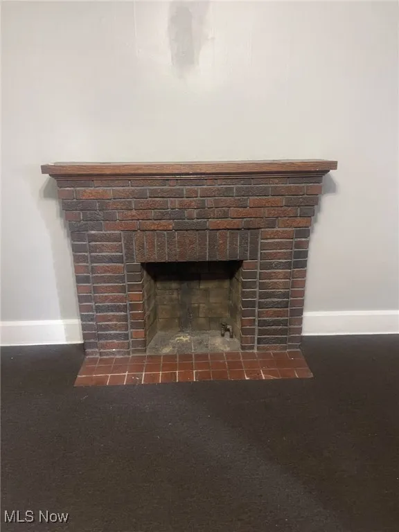 Detailed view of baseboards and a fireplace with flush hearth