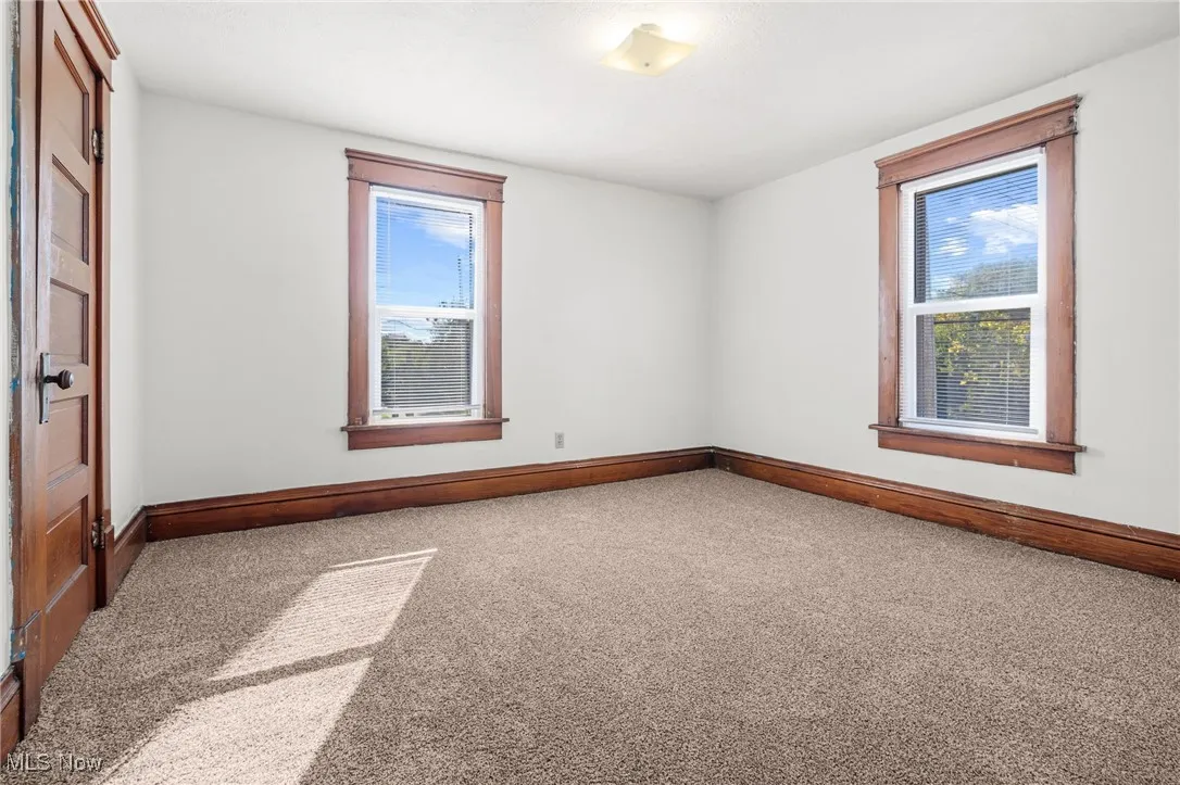 Unfurnished room with carpet floors and healthy amount of natural light