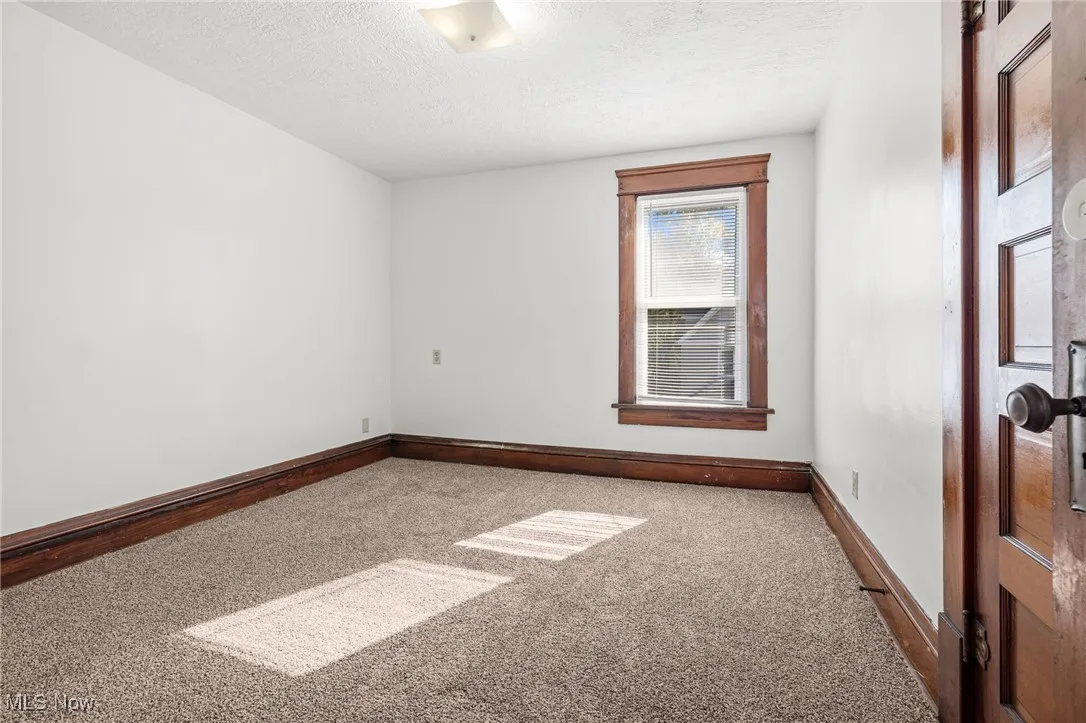 Unfurnished room featuring carpet flooring and a textured ceiling