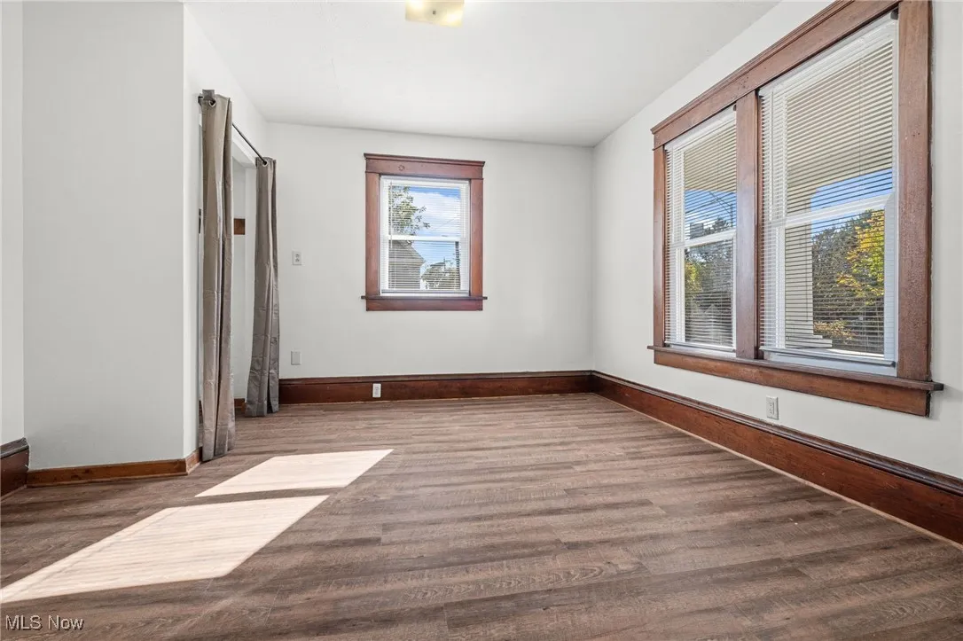 Unfurnished bedroom featuring dark wood-style floors and baseboards