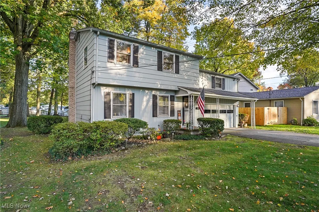 View of front facade with asphalt driveway and a chimney