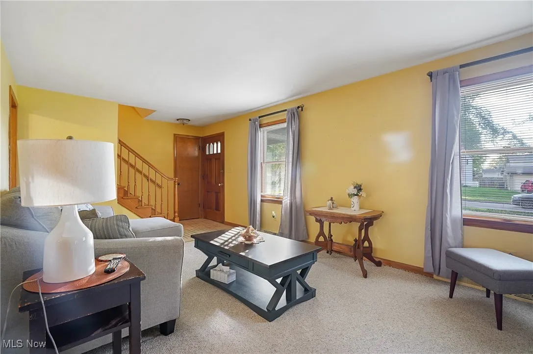 Living room with stairs and light carpet