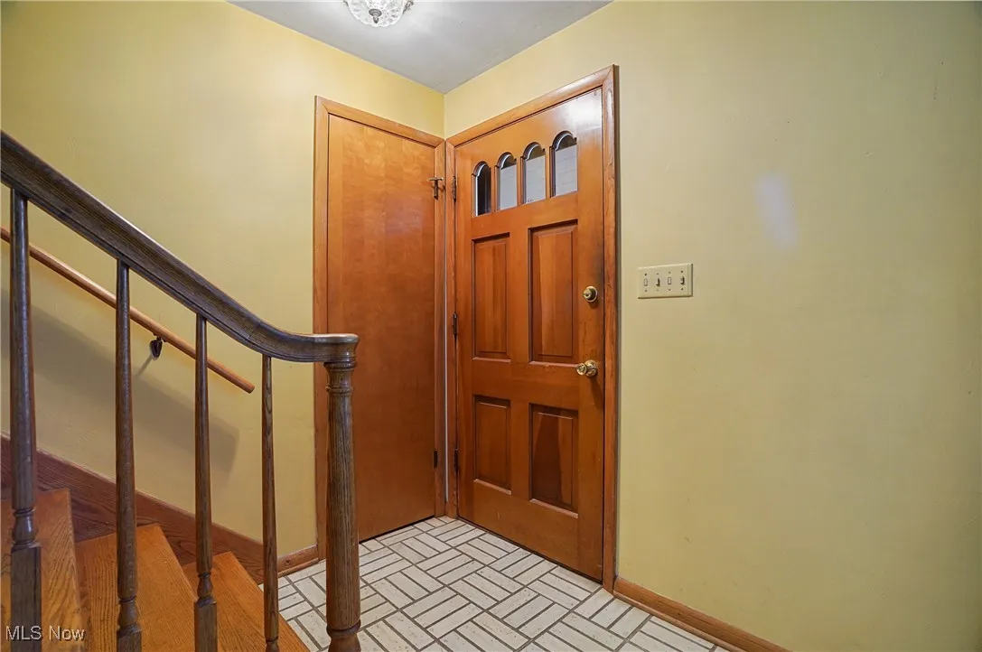 Entrance foyer featuring stairs and brick patterned floors
