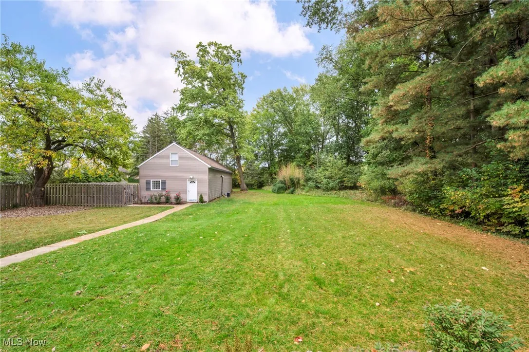 View of yard featuring view of wooded area and a garage