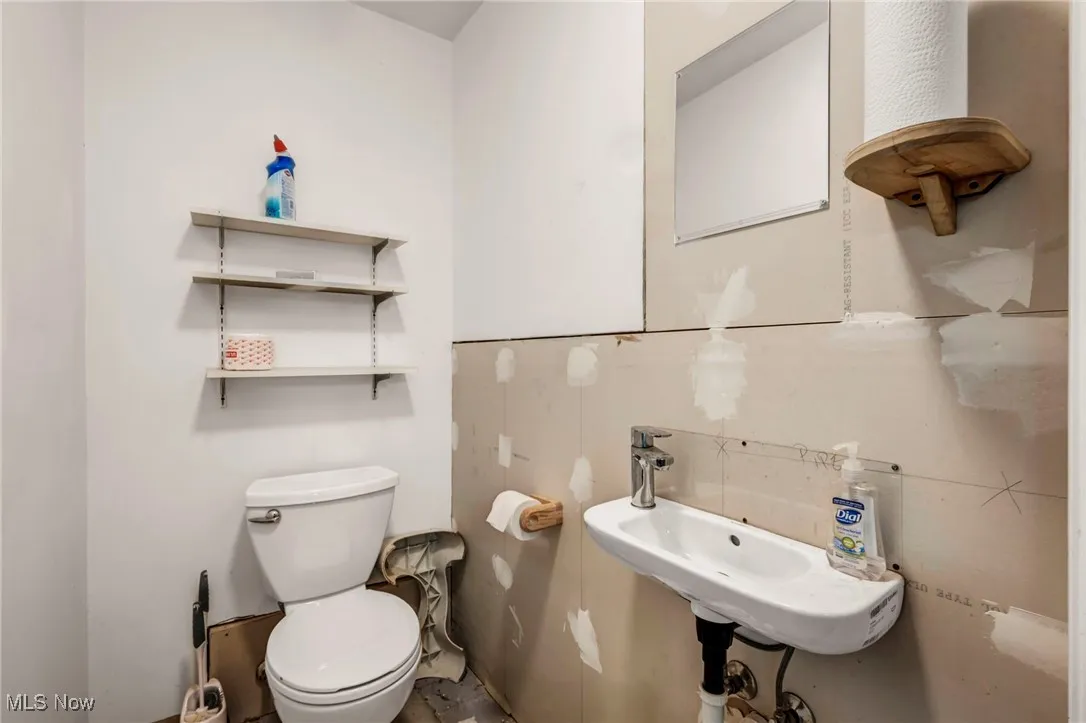 Half bathroom with toilet and a sink in garage
