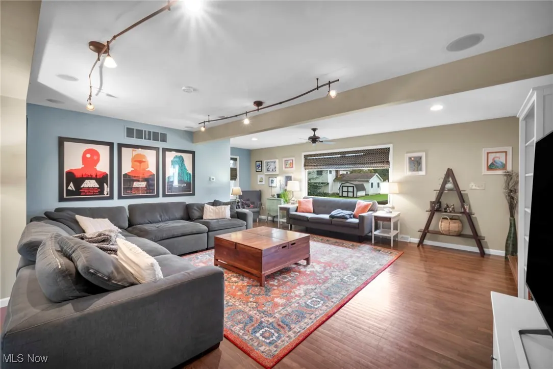 Living area featuring ceiling fan, wood finished floors, and track lighting
