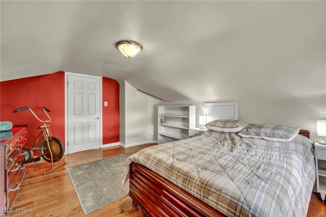 Bedroom with light wood-style flooring and lofted ceiling