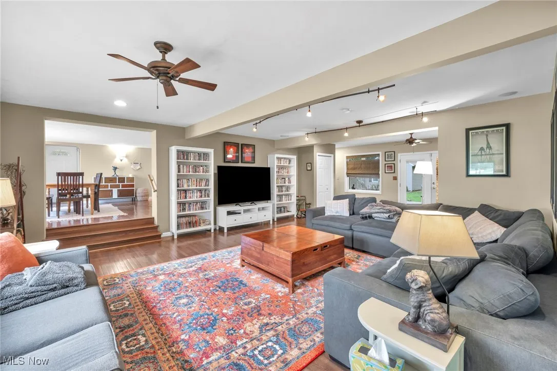 Living room with ceiling fan, rail lighting, and wood finished floors