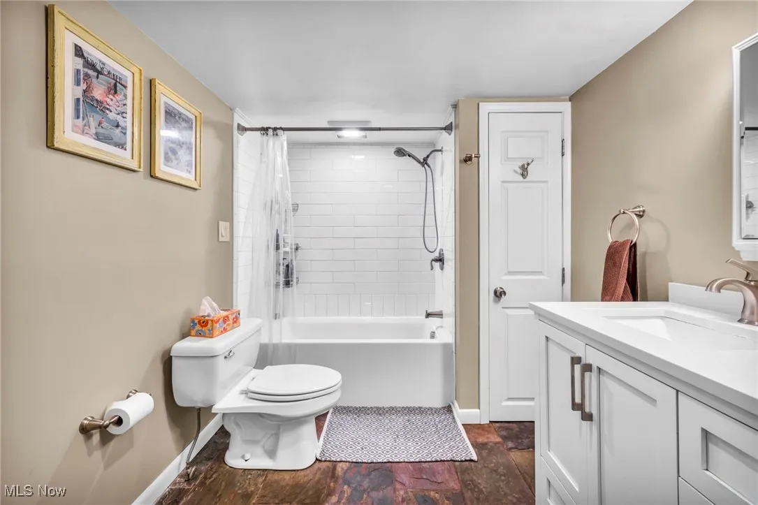 First floor full bath featuring shower / bath combination with curtain and vanity
