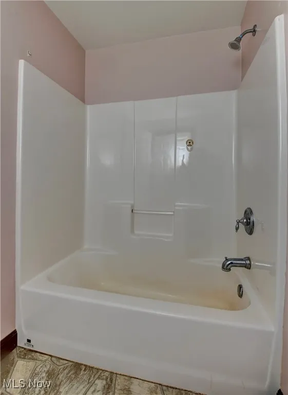 Bathroom with tile patterned floors and  shower combination