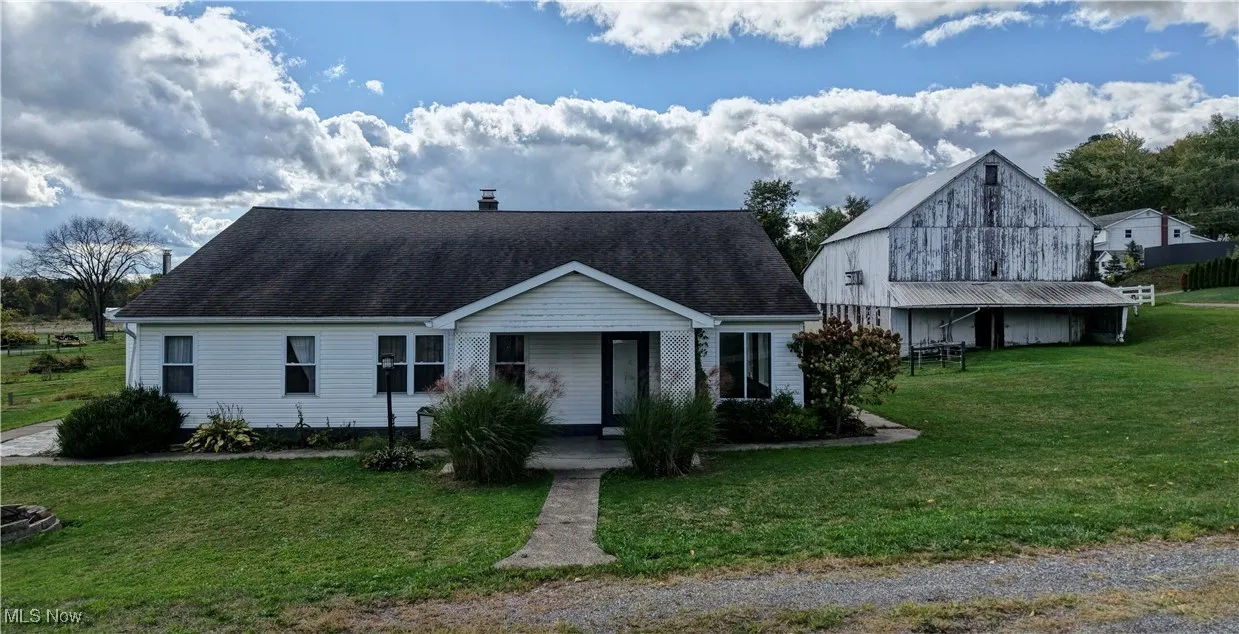 View of front of house featuring a front lawn, a chimney, and a shingled roof
