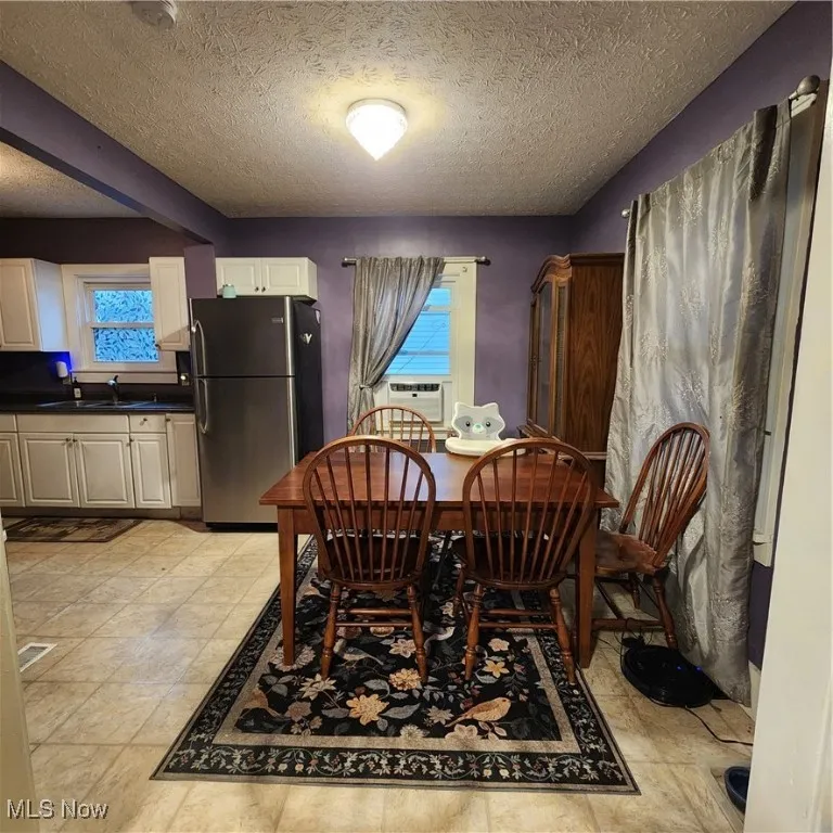 Dining room with a textured ceiling and cooling unit