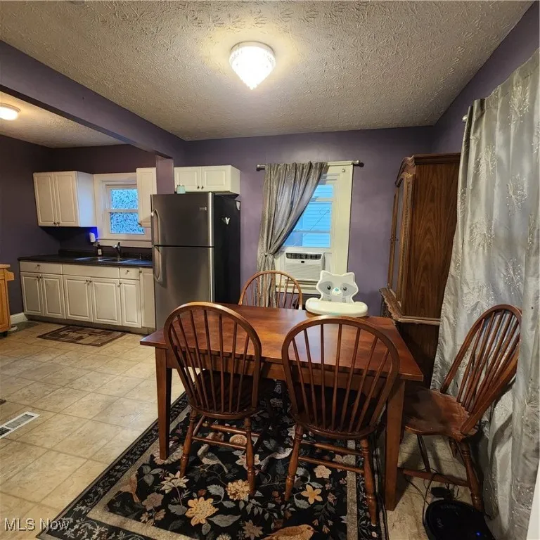 Dining room featuring a textured ceiling and cooling unit