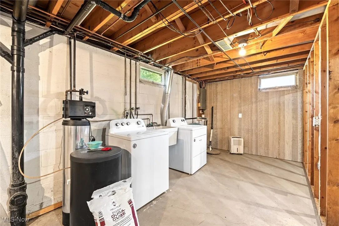 Laundry room featuring washing machine and clothes dryer and concrete flooring