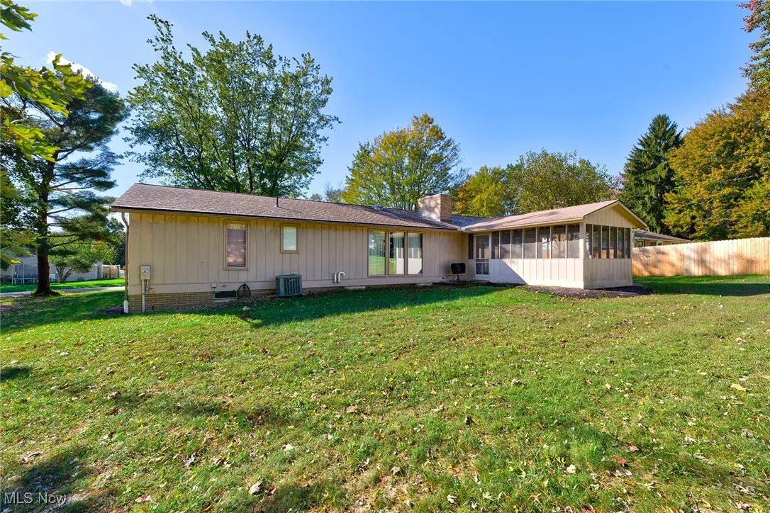 Rear view of property featuring a lawn and a chimney