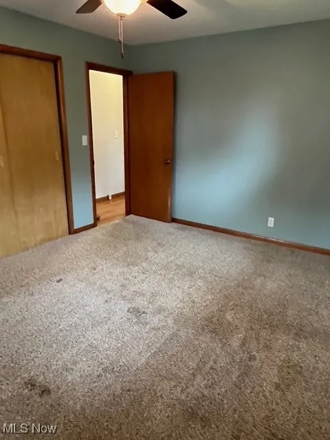 Unfurnished bedroom featuring a closet, carpet flooring, and ceiling fan