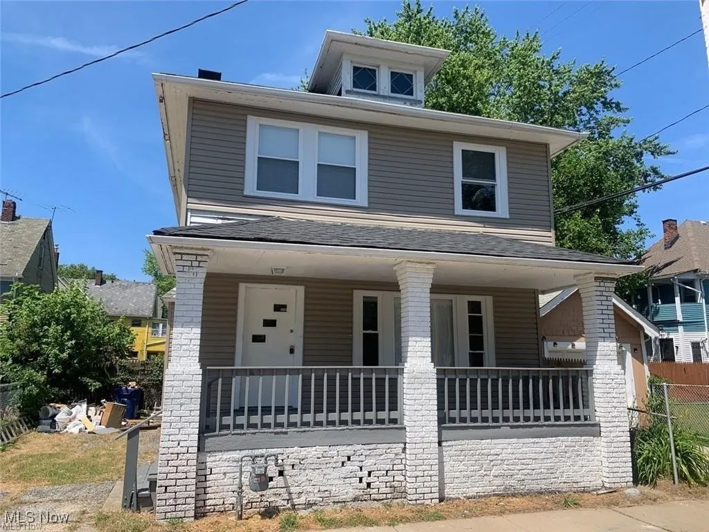 American foursquare style home with a porch and a shingled roof