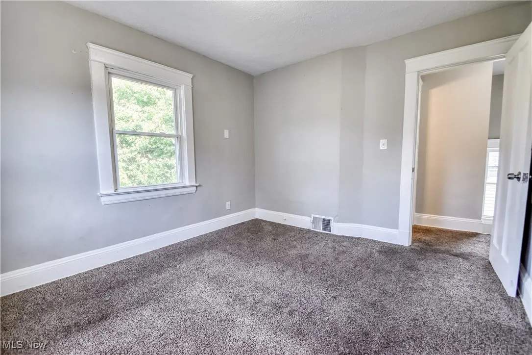 Unfurnished room with carpet flooring and a textured ceiling