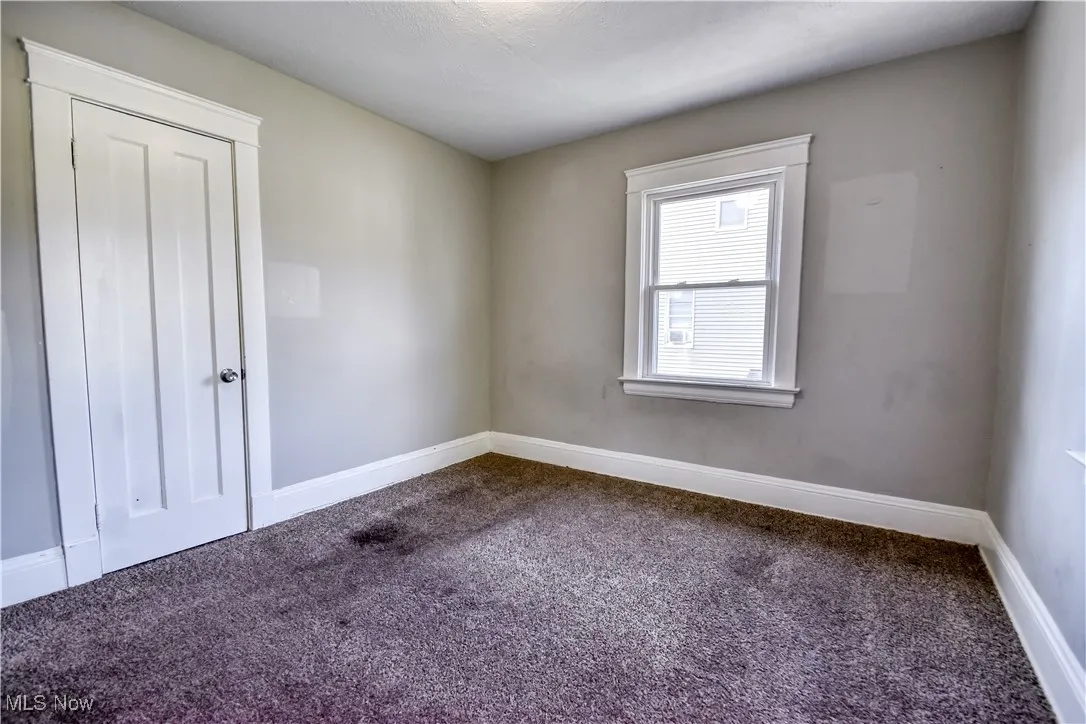 Spare room with dark colored carpet