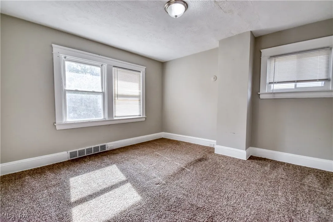 Spare room with carpet, healthy amount of natural light, and a textured ceiling