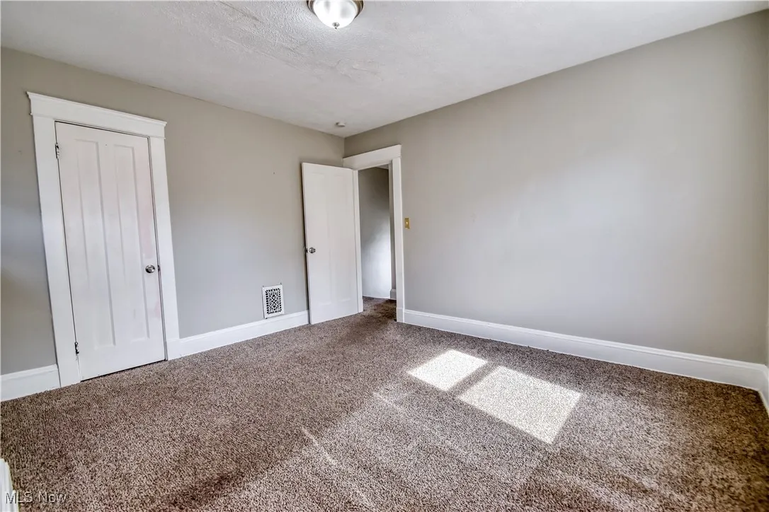 Unfurnished bedroom featuring carpet floors, a textured ceiling, and a closet