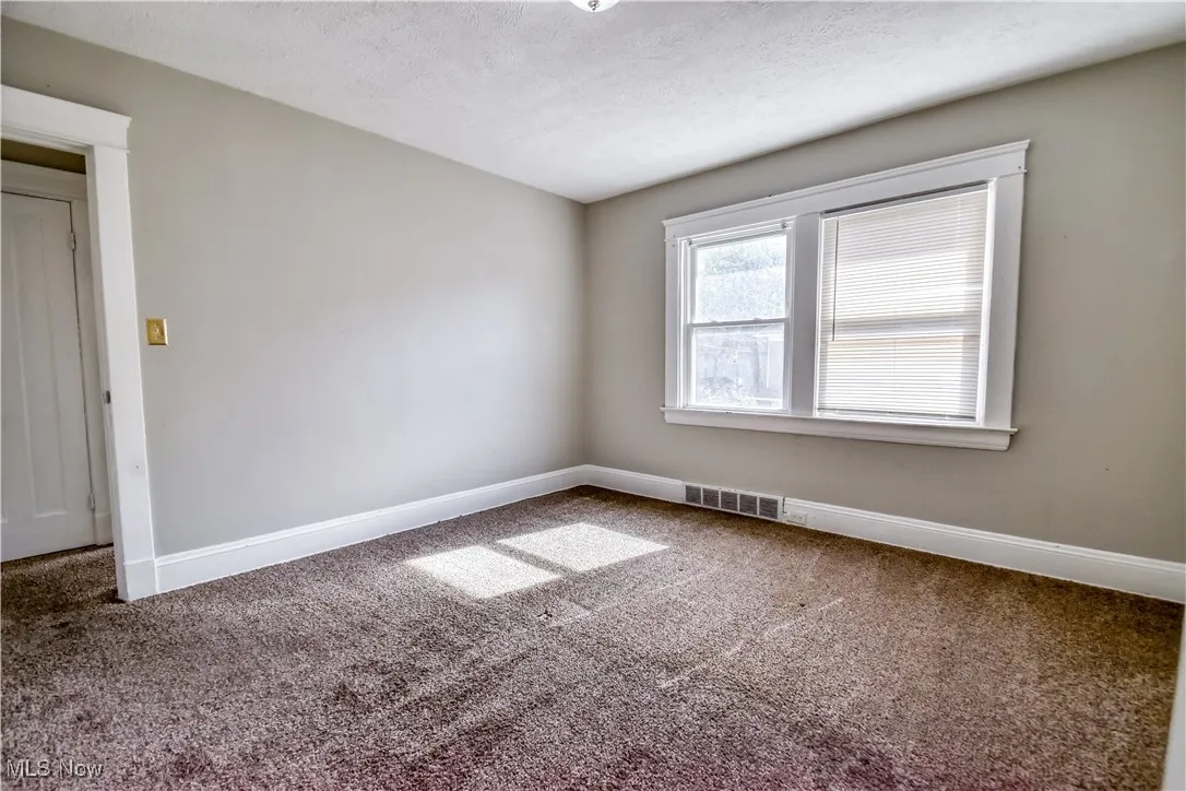 Unfurnished room featuring carpet floors and a textured ceiling