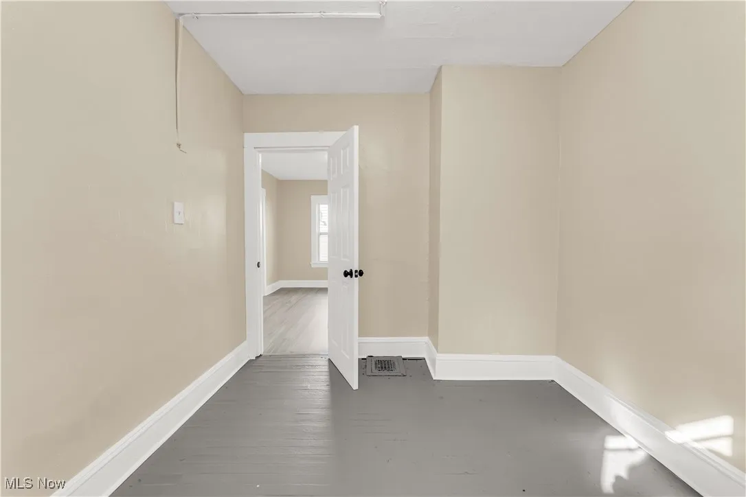 Empty room featuring wood-type flooring and baseboards