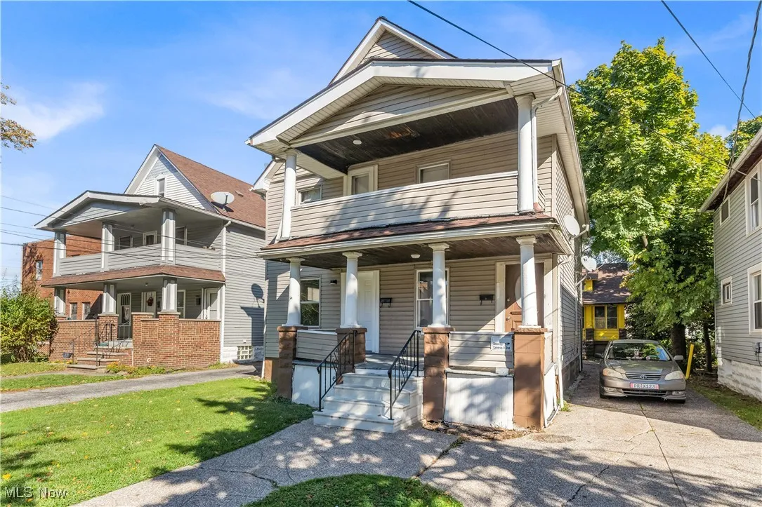 View of front of home featuring covered porch, a front lawn, and a balcony