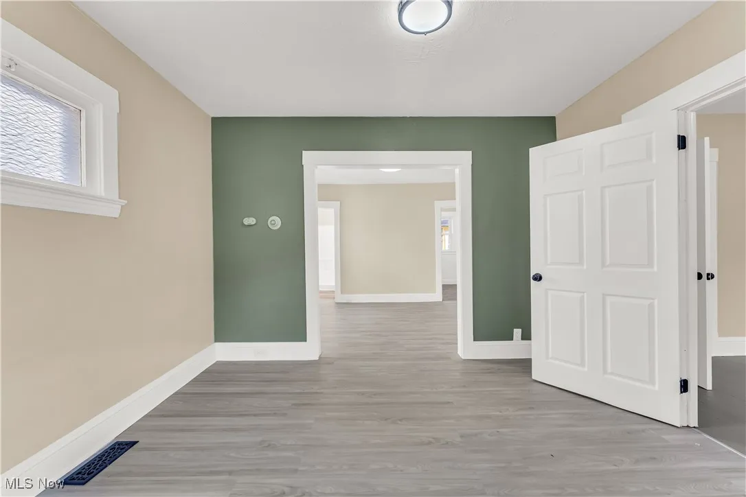 Unfurnished room with wood finished floors and baseboards