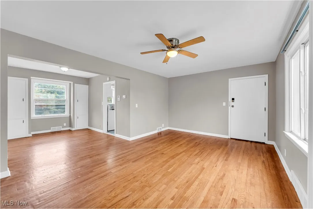 Empty room with light wood-style floors and ceiling fan