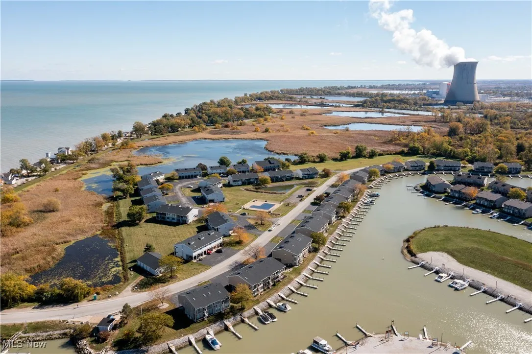 Aerial view of property's location featuring a nearby body of water and nearby suburban area