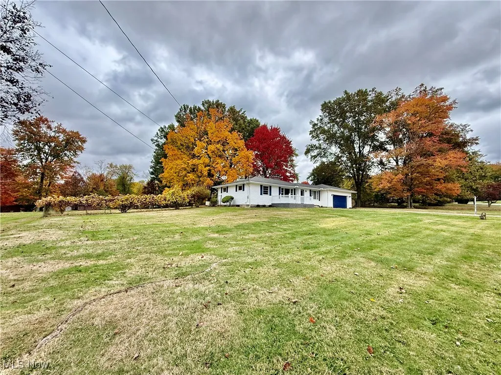 View of green lawn featuring a garage