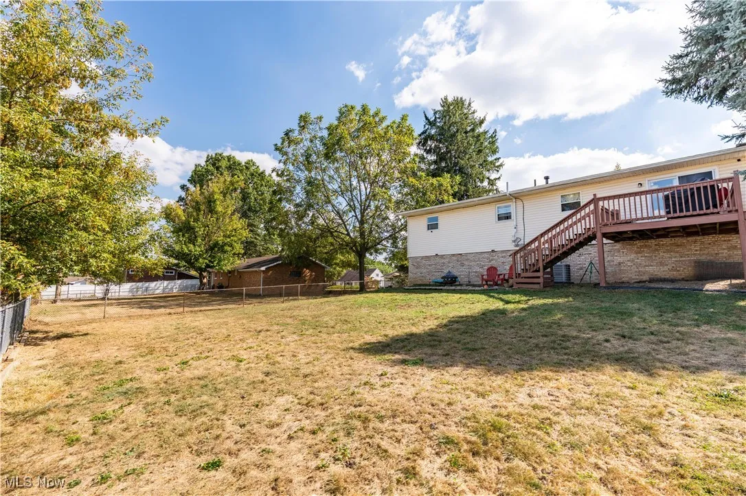 Fenced backyard with stairway and a wooden deck