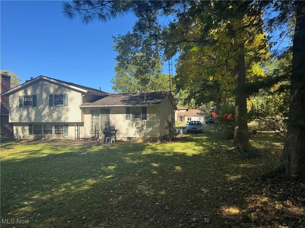 Rear view of house featuring a yard and a chimney