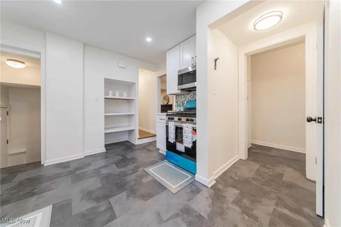 Kitchen featuring white cabinets, appliances with stainless steel finishes, tasteful backsplash, built in shelves, and recessed lighting