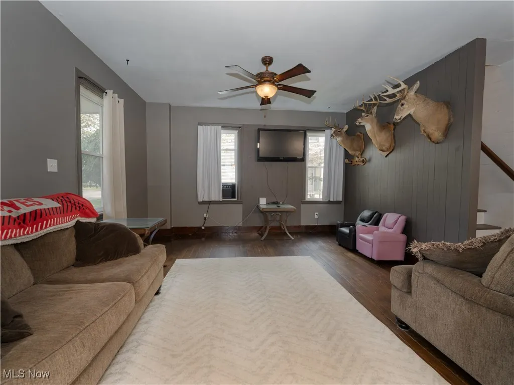 Living room with wood finished floors and a ceiling fan
