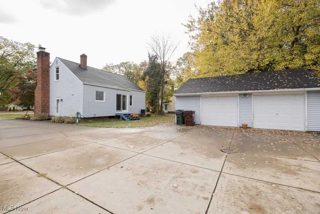 View of property exterior with an outdoor structure, a garage, and entry steps