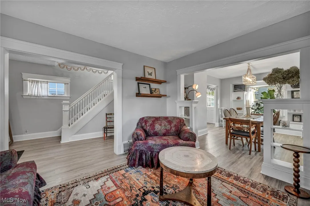 Living room with light wood-style flooring, a textured ceiling, and stairs