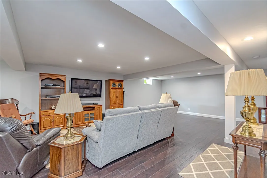 Living area with recessed lighting and dark wood-style flooring