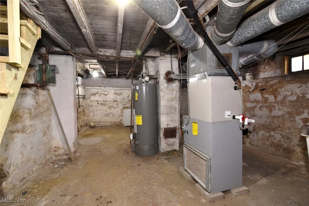 Unfinished below grade area with heating unit and gas water heater