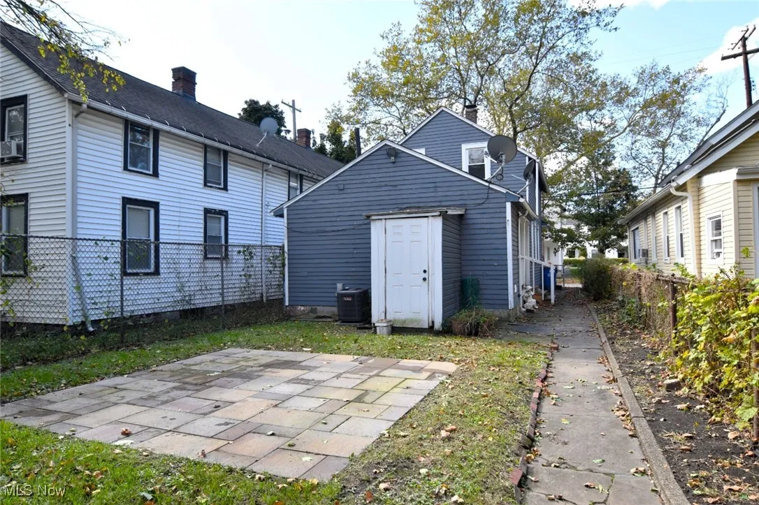 Back of house with a fenced backyard and a chimney