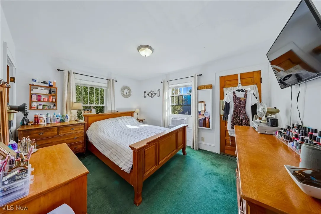 Bedroom with dark carpet and a desk