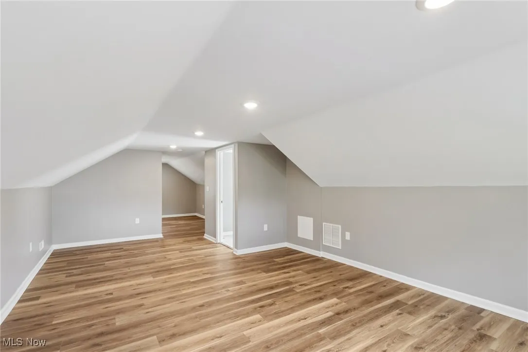 Bonus room featuring light wood-style flooring, lofted ceiling, and recessed lighting
