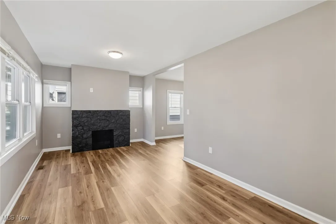 Unfurnished living room with a fireplace and light wood-style floors