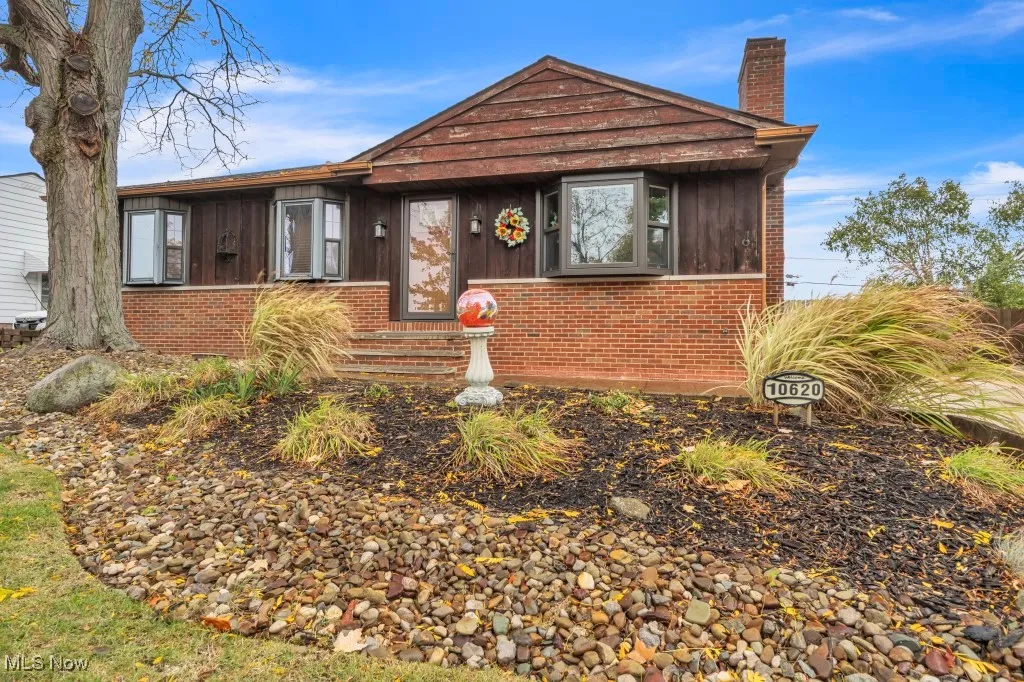 Bungalow-style house with a chimney and brick siding