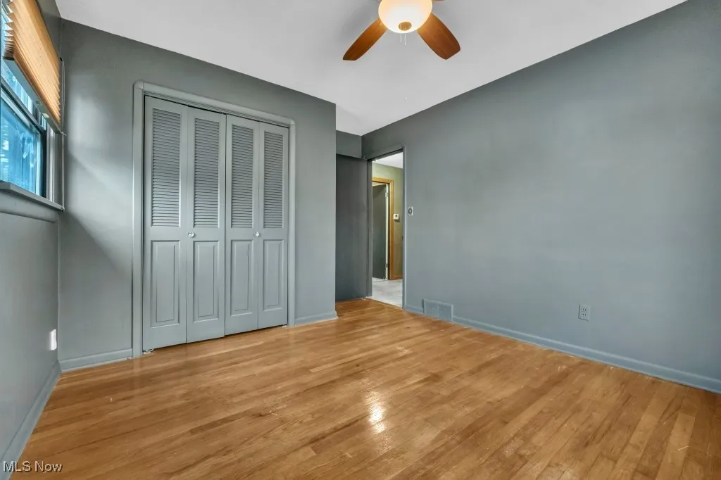 Unfurnished bedroom featuring wood finished floors, a closet, and ceiling fan